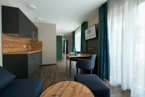 Hotel Zum Grünen Baum في Pfahlheim: غرفة معيشة مع طاولة ومطبخ