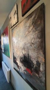 a group of paintings hanging on a wall at gîte Artbnb in Armbouts-Cappel