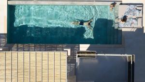 ツォウカラデスにあるEpiphany Villas Lefkadaのスイミングプール水泳の人々の絵画