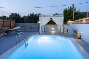 a swimming pool on a patio with a table and chairs at Villa Bella Gonia in Gonia