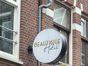una señal redonda en el lateral de un edificio de ladrillo en BEAUTiQUE HOTEL CITY CENTRE, en Ámsterdam
