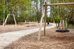 a swing set in a park with a playground at Bades Huk Ferien-Resort in Hohenkirchen