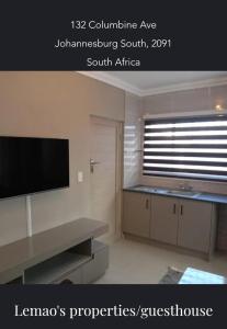 ein Wohnzimmer mit einem Flachbild-TV an der Wand in der Unterkunft Lemao Properties/guest house in Johannesburg