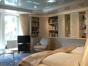 a bedroom with a bed and a chair and book shelves at Die Villa Mettmann in Mettmann