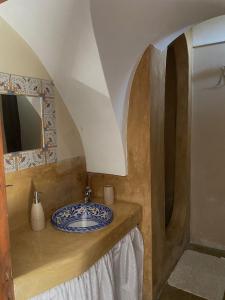 uma casa de banho com um lavatório e um espelho em Dammusi Rekale em Pantelleria