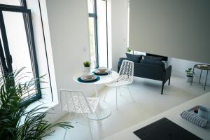 a living room with a table and chairs and a couch at PORTARIA HOUSING in Aveiro