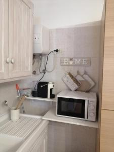 a microwave sitting on a counter in a kitchen at Lo Chalet in Ponte Galeria +18 photos