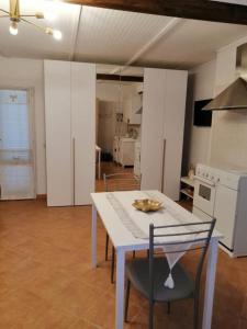 uma cozinha com uma mesa branca e cadeiras num quarto em Lo Chalet em Ponte Galeria