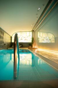 a swimming pool with blue water in a building at Hotel Plaza in A Coruña