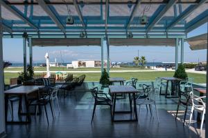 a restaurant with tables and chairs and a view of the ocean at Fani Luxury Apartments Stavros in Stavros