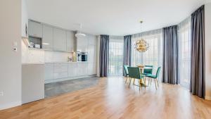 a kitchen and dining room with a table and chairs at Apartamenty Sun & Snow Nadmorskie in Sopot