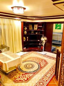 a living room with a table and a rug at THE MANSION- Near NAIA Airport Terminal PASAY in Manila