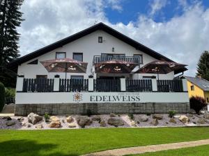 a large white building with a sign in front of it at Wellness Hotel Edelweiss in Liberec