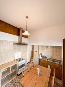 a kitchen with a wooden table in a kitchen at Casa rosa sull'appennino tosco emiliano in Barigazzo