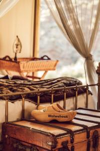 a pair of shoes sitting on top of a bed at Wolwehoek Private Reserve in Montagu