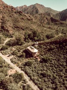 une petite maison sur le côté d'une montagne dans l'établissement Wolwehoek Private Reserve, à Montagu