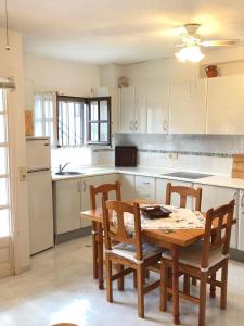 a kitchen with a wooden table and chairs and a kitchen with white cabinets at Marino114 in Alcossebre