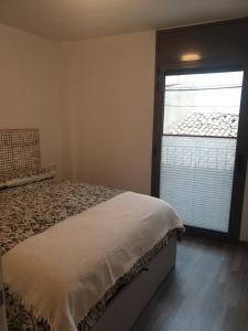 um quarto com uma cama e uma grande janela em Apartament Cèntric a Ribes de Freser Vall de Núria em Ribes de Freser