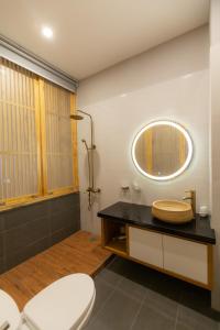 La salle de bains est pourvue de toilettes et d'un miroir. dans l'établissement Nguyễn Tài Hostel & Coffee Đà Lạt, à Đà Lạt