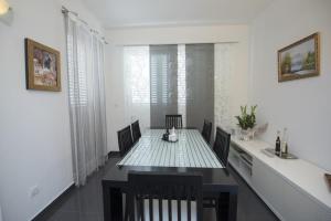- une table à manger et des chaises dans une pièce blanche dans l'établissement Holiday home Elijah Creek, à Split