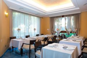 a dining room with white tables and chairs at Hotel Villa Albani in Nocera Superiore