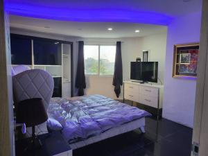 Dormitorio con cama, escritorio y TV en Spacious 2 bedroom. Home comfort + hotel amenities, en Ángeles