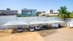 a group of cars parked in a parking lot with umbrellas at Ville Hotel Gramadão in Votuporanga