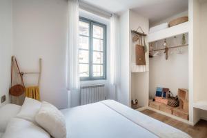 a white bedroom with a bed and a window at Il Nido Tra Le Mura - by MyHomeInComo in Como