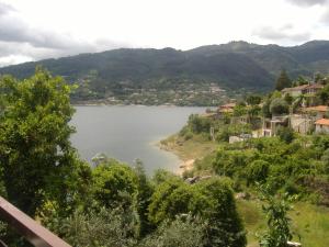 a view of a lake with houses and trees at Chalé da Fonte - T2 in Geres