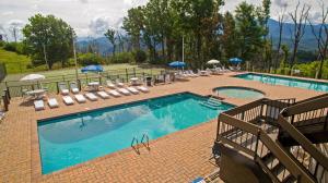 a swimming pool with lounge chairs and umbrellas at Rainwater Falls in Gatlinburg
