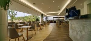 Kuching Park Hotel في كوتشينغ: مطعم فيه كراسي وطاولات وبار