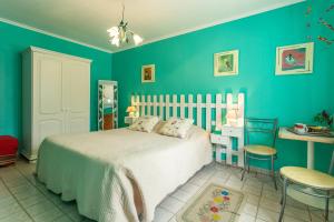 una camera da letto con un letto e una parete blu di Chambres et Table d'Hôtes Les Trois Marquets a Bourthes