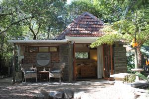 ein kleines Haus mit einem Tisch und Stühlen davor in der Unterkunft Schuilhoek Garden Terraces in Kapstadt