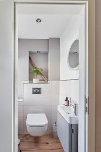 a white bathroom with a toilet and a sink at Ferienhaus Lichtblick in Freital