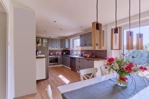 a kitchen with white cabinets and a table with flowers on it at Ferienhaus Lichtblick in Freital