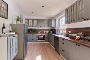 a kitchen with white cabinets and a stainless steel refrigerator at Ferienhaus Lichtblick in Freital