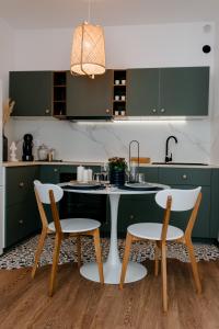 a kitchen with green cabinets and a table and chairs at Evo Residence Migdalului in Cluj-Napoca