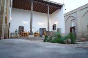 a building with a patio with tables and chairs at Carousel in Khiva