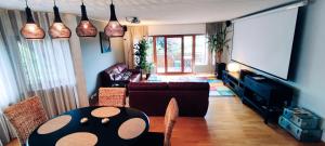 ein Wohnzimmer mit einem Sofa und einem Tisch mit Stühlen in der Unterkunft MaNaLa "120 m2" in Algolsheim