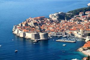 Apartments by the sea Dubrovnik - 18908 في دوبروفنيك: اطلالة جوية على مدينة في جزيرة في الماء