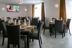 un comedor con mesas y sillas negras en Wellness Hotel Edelweiss, en Liberec