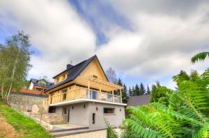 une maison avec un toit noir dans l'établissement Znamirowickachata SAUNA JACUZZI SPA, à Znamirowice