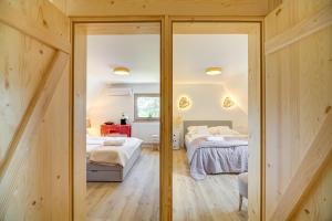 a bedroom with two beds and sliding glass doors at Znamirowickachata SAUNA JACUZZI SPA in Znamirowice