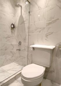 a white bathroom with a toilet and a shower at Kuching Park Hotel in Kuching