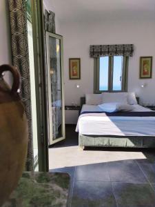 a bedroom with a bed and a large window at Anerada sunset in Ano Meria