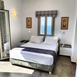 a bedroom with a large bed with a large window at Anerada sunset in Ano Meria