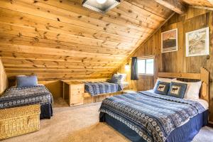 2 Betten in einem Zimmer mit Holzwänden in der Unterkunft Beaver Pond Chalet in Taos Ski Valley