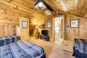 Blockhausschlafzimmer mit 2 Betten und einem TV in der Unterkunft Beaver Pond Chalet in Taos Ski Valley