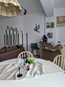 einen Esstisch mit einem weißen Tischtuch und Weingläsern in der Unterkunft AryaHome in Bistriţa