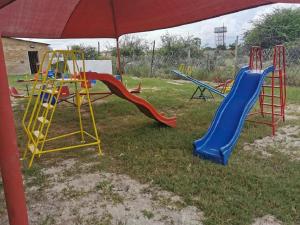 a group of playground equipment in the grass at Palmeiras Lodge Oshikango in Oshikango